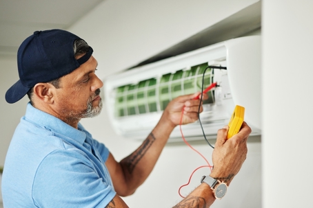 A technician repairs an air conditioner.