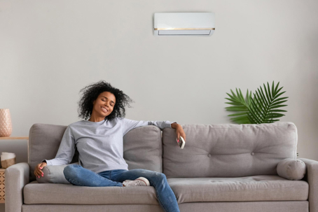 A smiling woman enjoys her air conditioning.