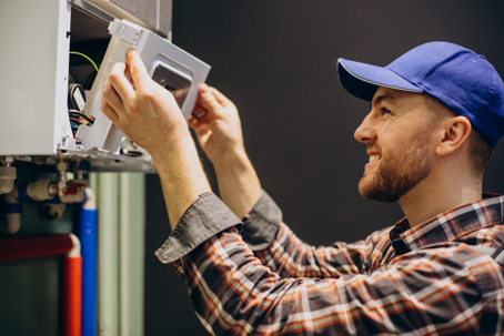 A friendly technician smiles while servicing a home appliance.