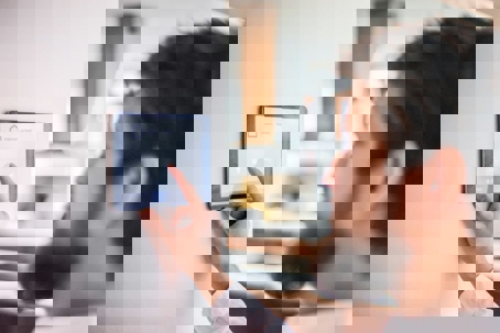 A man interacts with a wall-mounted smart home touchscreen.