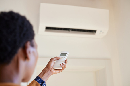 Person adjusting a ductless mini-split system.